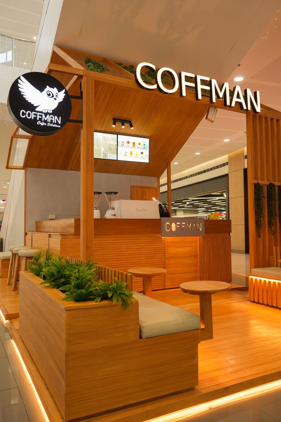 Coffman Coffee kiosk front view with timber-clad service counter and overhead menu signage