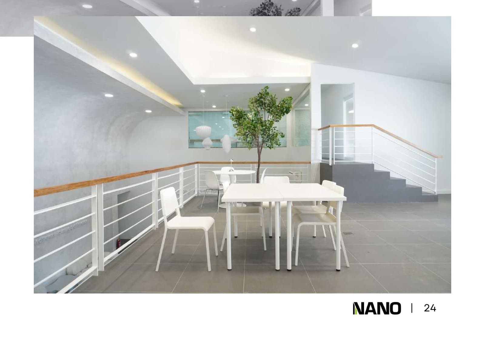 Open-plan workspace with white desks, blue chairs, and natural light